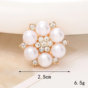 Detalle de dije de flor de perla de 2,5 cm con base dorada y cristales transparentes