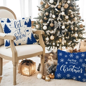 Blue Christmas pillow covers with reindeer and snow prints on cozy holiday sofa scene