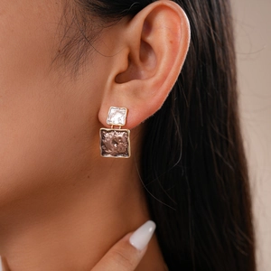 Detail of double-layer square gold earrings with irregular hammered texture on model