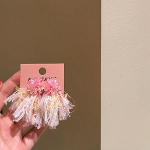 Detailed view of pink flower tassel earrings with lace and bead accents