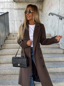 Detail of a brown double-breasted wool coat featuring a notch lapel and premium fabric texture