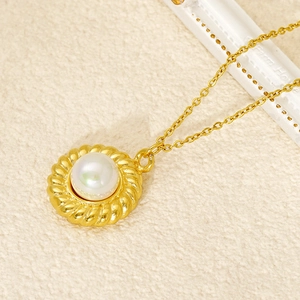 Collier élégant en titane doré avec pendentif perle ronde sur fond en tissu beige