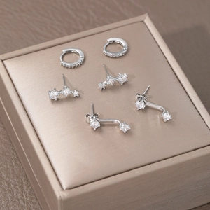 Macro view of silver zircon earring set including studs and hoops on a jewelry box