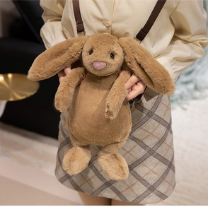 Brown long-eared bunny plush crossbody bag shown on a model in a cozy indoor setting