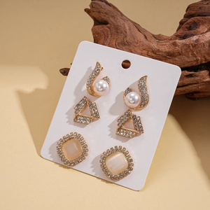Detail of vintage gold-tone earrings set with pearls and rhinestones on display card