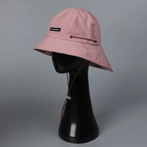 Detailed close-up of pink nylon sun hat featuring adjustable wind cord and brand label