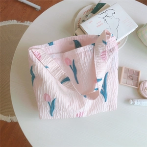 Gros plan d'un sac cabas tulipe rose en tissu gaufré avec des motifs floraux élégants