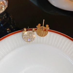 Detail of gold-plated deer antler stud earrings with Fu character and zircon pavé
