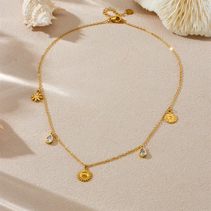 Macro detail of gold-plated starfish and shell charms on necklace over beige background