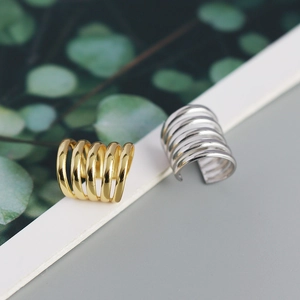 Macro shot of minimalist gold and silver multilayered C-shaped ear bone clips
