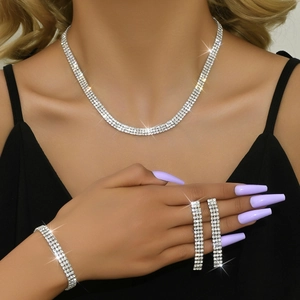 Close-up of elegant bridal jewelry set with three rows of sparkling rhinestones on model