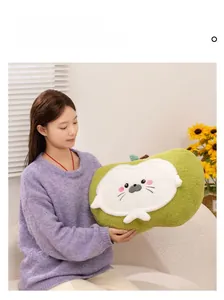 Green plush seal pillow held by a woman in a cozy home setting with sunflowers
