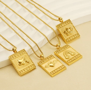 Detail of four gold square pendant necklaces with embossed heart and crown patterns