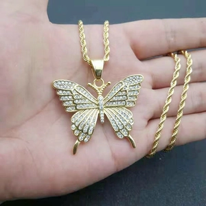 Close-up of golden butterfly pendant with sparkling cubic zirconia on twist chain