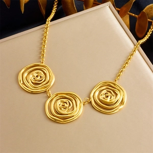 Detailed view of the layered gold spiral flower pendants on a thick link chain necklace
