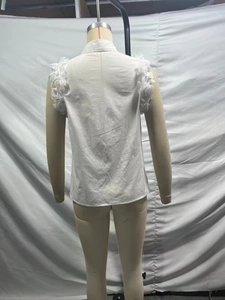 Detail of white sleeveless shirt back featuring 3D floral accents on the shoulders