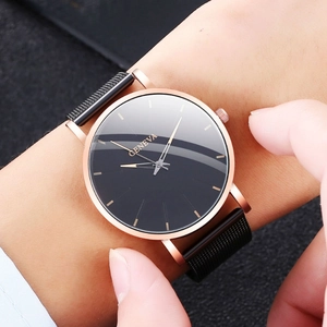 Reloj Geneva minimalista con caja de oro rosa y correa de malla negra en la muñeca