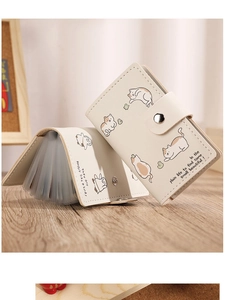 Detail of cream white cat card holder showing accordion-style slots and snap button