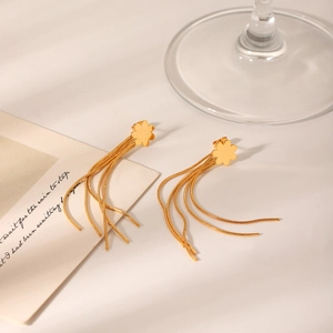 Elegant gold flower stud earrings with long snake chain tassels on minimalist background