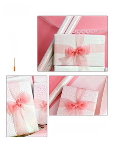 Detail of laser iridescent heart-patterned gift wrapping paper with pink ribbon