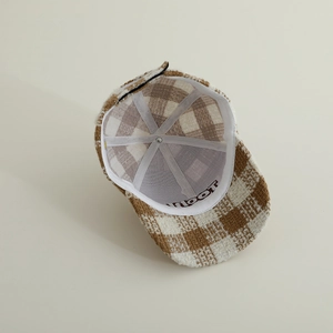 Detail showing inner lining and reinforced structure of the brown plaid baseball cap