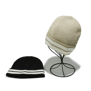 Détails de la texture tricotée et rayures contrastées sur bonnets d'hiver noir et beige