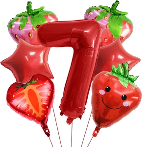 Detail shot of strawberry birthday balloons showing the red number seven and cute fruit designs