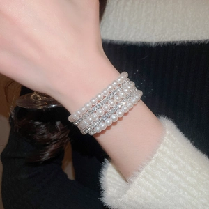 Detailed view of multilayer pearl bracelet with shimmering rhinestones on wrist