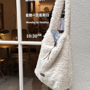Close-up of white lamb wool tote bag featuring brown drawstring and blue plaid lining