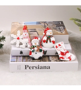 Detailed view of assorted polymer clay Christmas charms like snowmen and boots on books