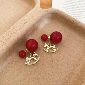 Détails des boucles d'oreilles cheval à bascule avec perles rouges et cristaux