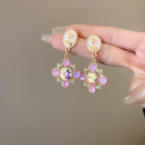 Détail de boucles d'oreilles vintage fleurs avec portrait camée et cristaux colorés