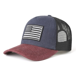 Detail of USA flag patch on breathable mesh trucker hat with distressed red brim