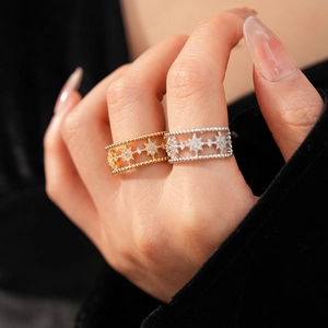 Macro shot of gold and silver double-layer star rings with zircons on a hand