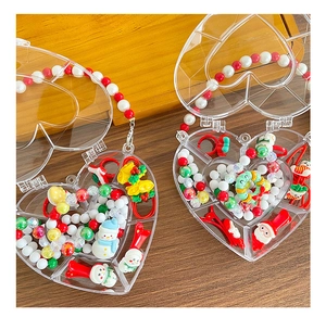 Detail of Christmas DIY jewelry kit with Santa charms and beads in a heart-shaped case