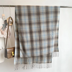Detailed view of the blue and brown plaid scarf featuring soft tassel edge details