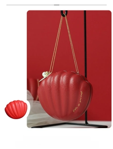 Macro view of shell shaped wedding candy box in red with pearl clasp and golden chain