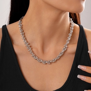 Detailed close-up of a silver beaded cluster necklace worn by a model on the neckline