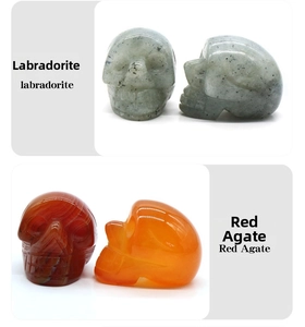 Detailed front and side view of hand-carved natural labradorite and red agate skull figurines