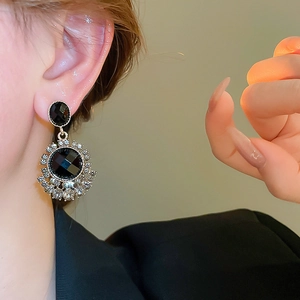 Close-up of vintage black crystal earrings with sparkling rhinestones on model ear