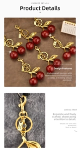 Detail of cherry keychain with gold metal chain, red resin fruit and letter tag charms