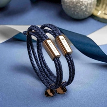 Detail of blue braided leather couple bracelets with Forever Love rose gold engraving