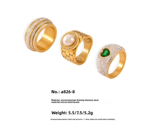 Detailed view of titanium steel gold rings featuring crystals, pearls, and green zircon