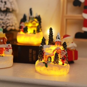 Close-up of glowing resin gingerbread house with Santa and warm LED lights