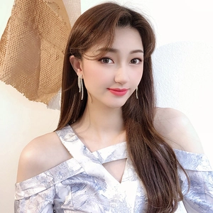 Close-up of sparkling long tassel earrings with silver finish on elegant model