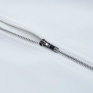 Detailed close-up of a high-quality silver metal zipper on white long-sleeve sweatshirt