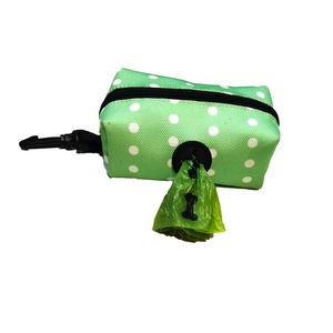 Close-up of green polka dot pet waste bag dispenser with hook and internal plastic bags