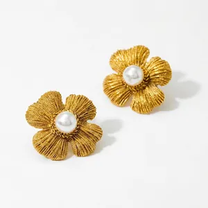 Elegant gold flower earrings with pearl center featuring detailed brushed metal texture