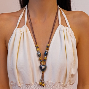 Collier bohème en perles avec pendentif cœur en céramique et pompon tons terreux