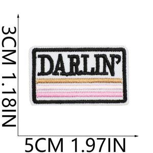 Detail of DARLIN' embroidered patch with pink stripes and dimensions 5x3cm